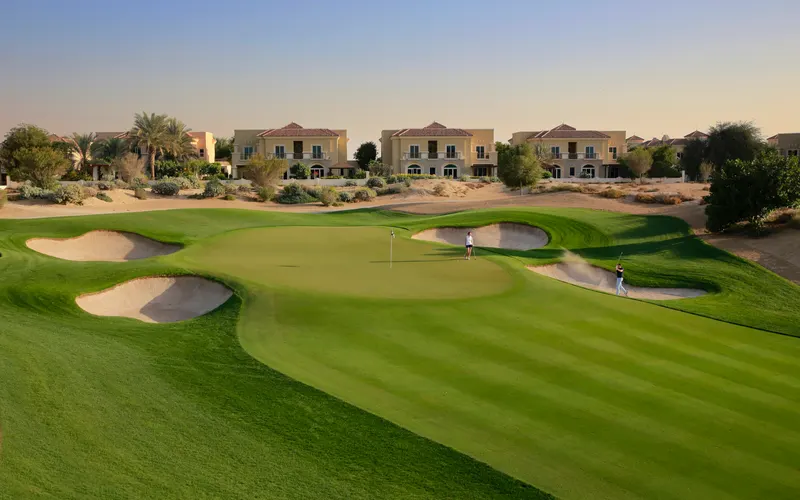 Golf fairway and completed villas beside The Els Club eleventh hole in Dubai Sports City