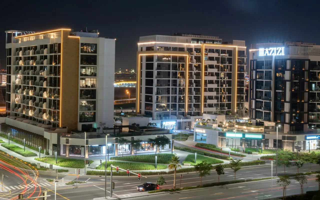 Illuminated apartment buildings and traffic light trails at Azizi Riviera in Meydan One